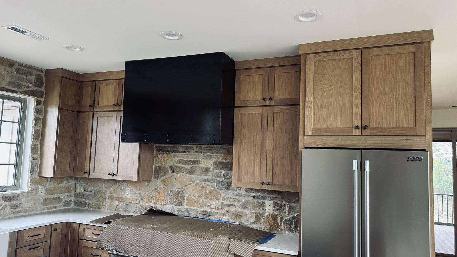Custom built-in refrigerator surround with seamless white panels and precision-fitted crown molding