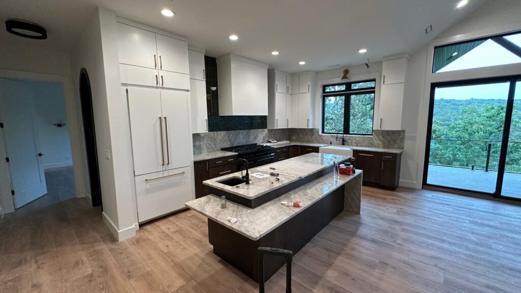 Custom light gray floor-to-ceiling cabinetry with an integrated refrigerator surround and elegant crown molding.