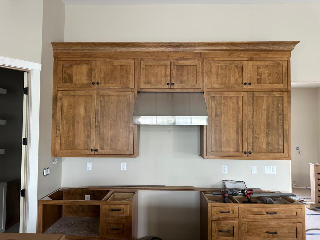 Bespoke wood cabinets with seamless professional-grade appliance integration and natural stone backsplash