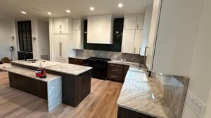 Luxury custom kitchen with dark wood island and premium marble countertops by Max Craft