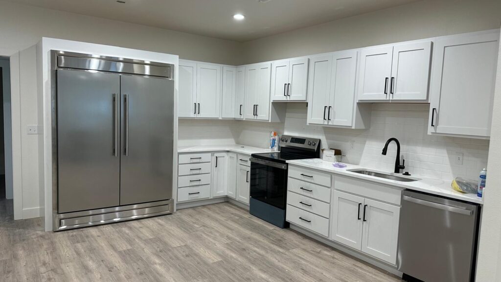 High-end bespoke white cabinetry and integrated professional appliances in a modern kitchen design.