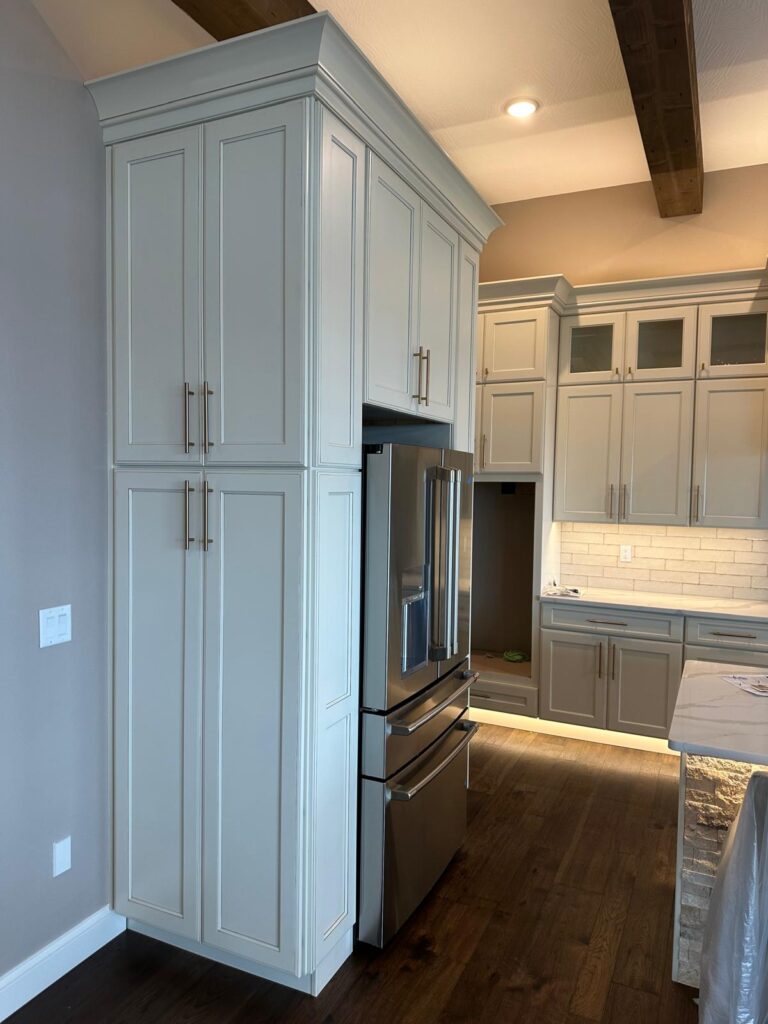 Handcrafted kitchen island with stone cladding and custom gray cabinets by Max Craft.