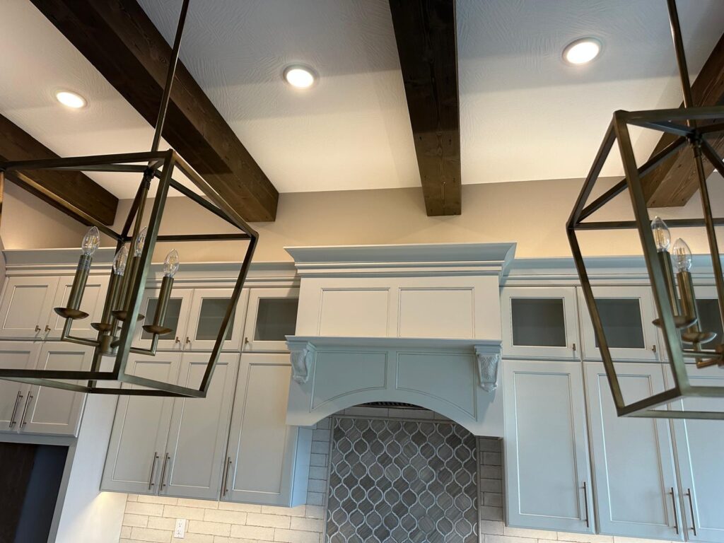 Handcrafted kitchen island with stone cladding and custom gray cabinets by Max Craft.