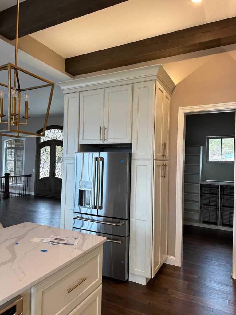 Handcrafted kitchen island with stone cladding and custom gray cabinets by Max Craft.