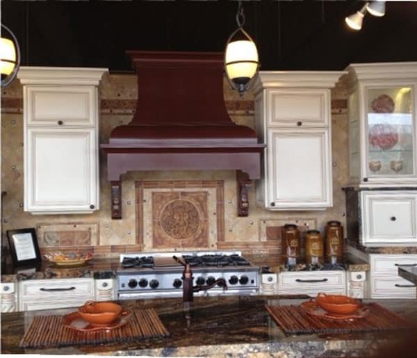 An architectural luxury kitchen design highlighted by a custom dark-stained D-Series wood range hood featuring sweeping lines, classic corbels, and a custom-scaled chimney.