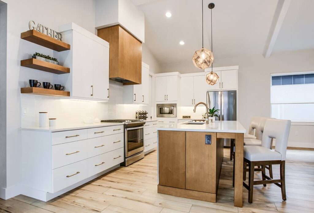 Vertical Grain Hood: The Art of Height – Featured here is a modern, open-plan kitchen showcasing an ornate, hearth-style range hood with vertical wood grain.